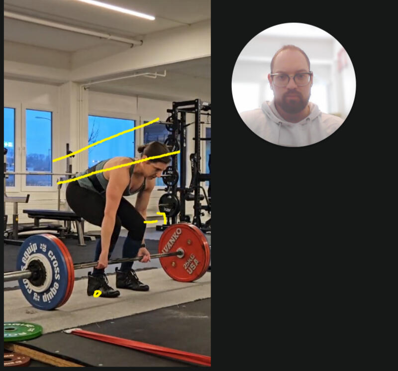 Powerlifting coach using video feedback tools to analyze and improve deadlift technique, offering personalized online coaching for strength athletes worldwide.