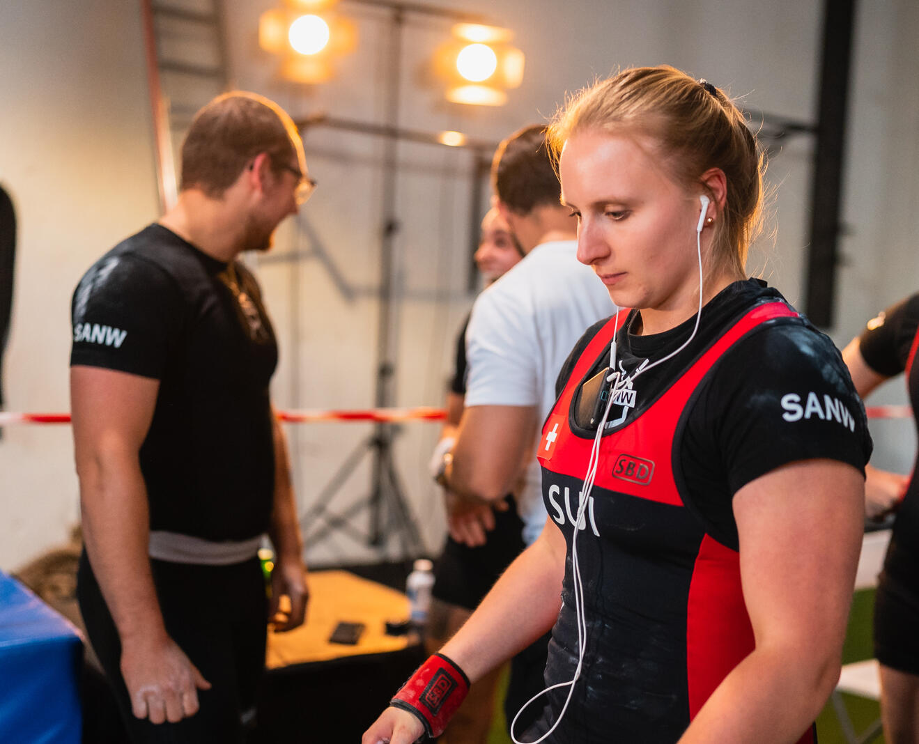 Powerlifting coach and athlete preparing backstage at a Zürich competition, demonstrating focused coaching, mental preparation, and elite strength training support.